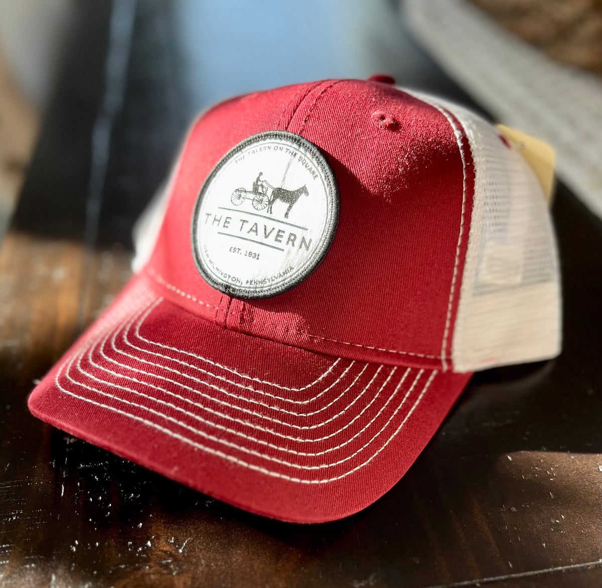 Sport your love of The Tavern On The Square with our comfortable, durable trucker hat! This hat features an iconic style crafted of soft, breathable fabric, a net back, snap closure, and a logo patch on the front featuring our historic logo.  o   Structured medium profile  o   Polyester mesh back  o   100% cotton twill front panels and brim  o   Slightly curved visor  o   Plastic snap closure   o   One Size Fits Most